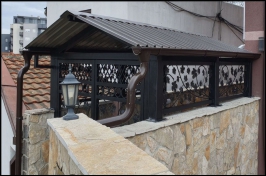 Kapija i pokriveni ulaz u zgradu od kovanog gvožđa i pokrivke trapeznog lima sa olucima