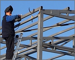 Varilac zavaruje čelični profil na konstrukciju. Uslužno zavarivanje MIG, MAG i E postupkom